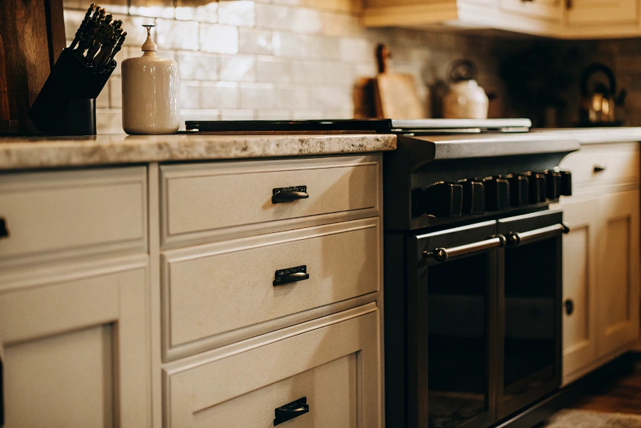 A pristine white shaker kitchen with classic subway tile and marble countertops